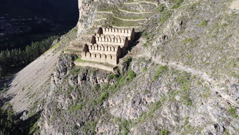 Historic-town-site-of-Ollantaytambo-cut-out-of-hillside-in-Peru,-aerial-ascend