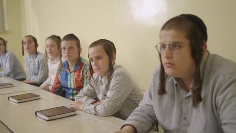 ultra--Orthodox-Jewish-students-with-a-kippahs-lerning-in-class-listening-to-their-teacher,-close-up