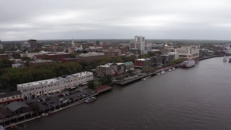 Wide-push-in-aerial-shot-of-historic-downtown-Savannah-along-the-river-in-Georgia