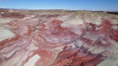 Drone-flying-over-unique-geology-in-Bentonite-Hills,-sunny-day-in-Utah,-USA