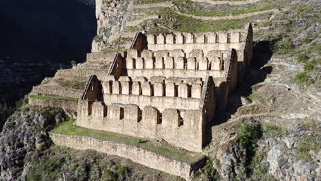 Historic-town-site-of-Ollantaytambo-cut-out-of-hillside-in-Peru,-aerial-dolly