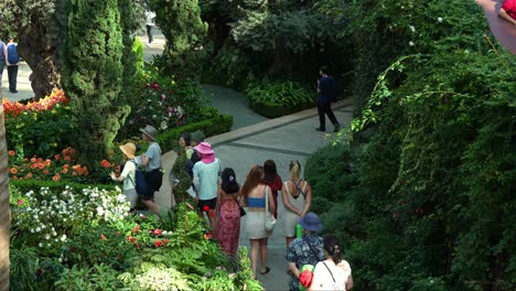 Touristen-Schlendern-Durch-Die-Blumenfelder-Und-Erkunden-Singapurs-Berühmte-Touristenattraktion,-Das-Gewächshaus-Mit-Blumenkuppel-In-Den-Gardens-By-The-Bay