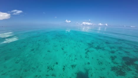 Clear-turquoise-ocean-gently-swaying-under-a-blue-sky,-captured-from-a-boat's-POV