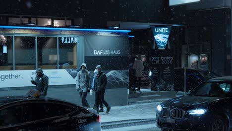 Panning-shot-of-Davos-high-street-at-night-time-showing-a-summit-venue-and-attendees
