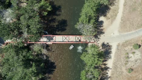 Static-top-dpwn-drone-footage-of-people-jumping-off-a-red-bridge-into-boise-river