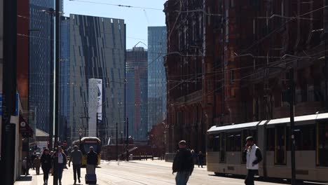Pedestrians-And-Trams-Move-Through-Manchester-City-Center-In-UK,-Wide-Shot