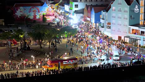 Aerial-orbit-above-Carnaval-performers-driving-along-waterfront-at-night