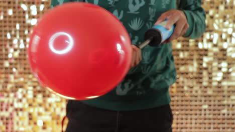 Using-a-manual-pump-to-inflate-a-red-latex-balloon