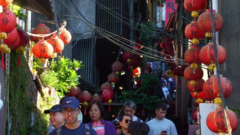 People-navigate-through-narrow,-steep-staircases-lined-with-shops-and-food-stalls,-exploring-the-quaint-mountain-village-town-of-Jiufen's-Old-Street