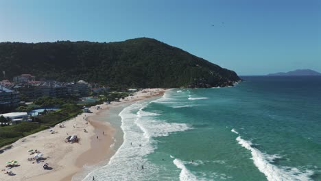Ein-Seitliches-Luftbild-Zeigt-Praia-Brava-Mit-Mehreren-Gleitschirmfliegern-Im-Hintergrund