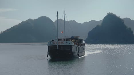 Vorderansicht-Eines-Lokalen-Bootes,-Das-In-Der-Bucht-Von-Lan-Ha-In-Vietnam-Segelt,-Mit-Wunderschöner-Landschaft-Im-Hintergrund