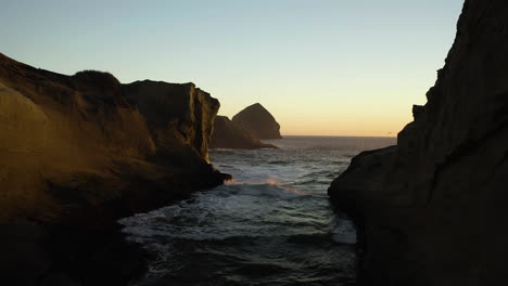 Sandstone-cliff-valley-cove-at-Cape-Kiwanda-with-Haystack-rock-at-sunset