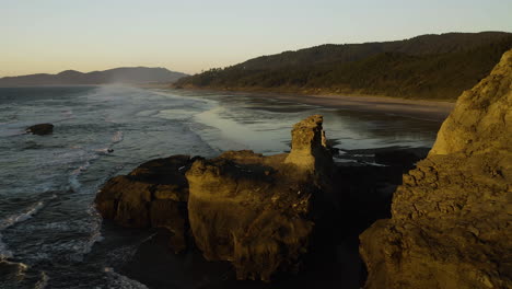 Aerial-establishing-overview-of-Cape-Kiwanda-and-sweeping-beach-flats-at-sunset,-Oregon-Coast