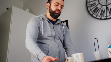 Bearded-Man-Putting-Away-The-Plates-And-Mugs-After-Washing