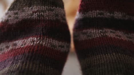 Feet-with-warm,-woolen-socks-on,-striped-knitted-socks,-closeup