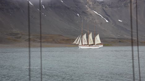 Vintage-Ship-With-Sailing-in-Fjord-Water-Near-Coast-of-Island-in-Svalbard-Archipelago,-Norway