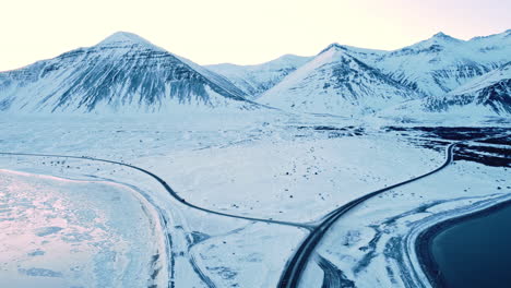 Luftaufnahme-Bei-Sonnenuntergang-Einer-Malerischen-Straße-In-Island-Wintersaison-Schneeweiße-Landschaft