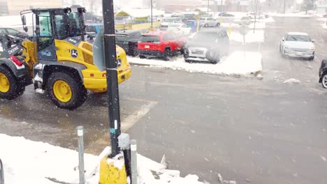 Yellow-Bulldozer-Clears-Pile-of-Snow-from-Shopping-Center-Parking-Lot