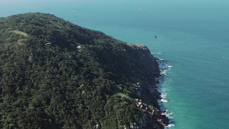 Mehrere-Gleitschirmflieger-Schweben-Anmutig-über-Das-Bergige-Gelände-Am-Praia-Brava-In-Florianopolis