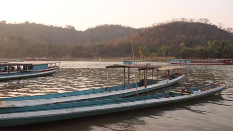 boats-docked-on-the-mekong-river-in-Luang-Prabang,-Laos-traveling-Southeast-Asia