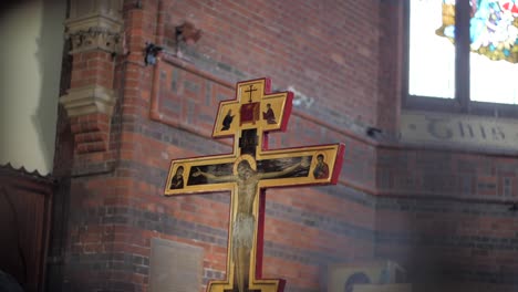 Handheld-shot-of-a-cross-in-an-old-church,-with-foreground-elements