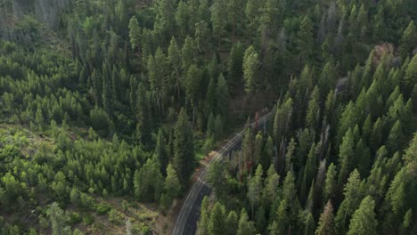 Imágenes-De-Drones-De-Una-Sinuosa-Carretera-De-Montaña-En-Las-Montañas-De-Dientes-De-Sierra-Con-Un-Automóvil-Conduciendo