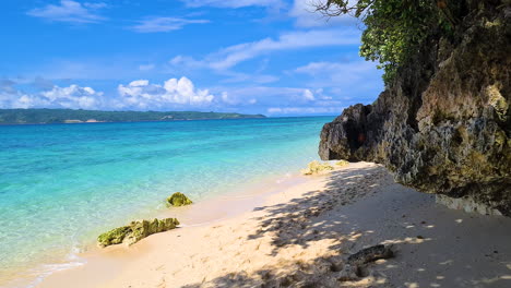 Exotischer-Strand-Mit-Weißem-Sand-Unter-Felsen-Und-Baumschatten-Auf-Einer-Tropischen-Insel