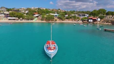 Aerial-orbit-parallax-around-bobbing-sailboat-anchored-off-coast-of-Caribbean-island