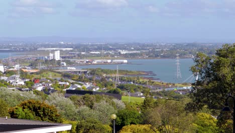 Cityscape-view-of-Auckland-New-Zealand,-car-traffic,-green-area,-highway-water-background-as-seen-from-Mount-Cecilia