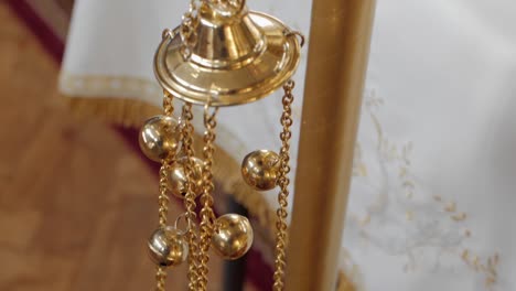 Ornate-censer-with-decorative-chains-and-bells,-detailed-close-up