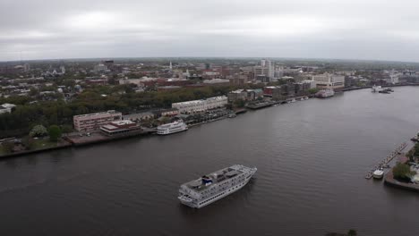 Aerial-descending-close-up-shot-of-a-riverboat-cruise-on-the-Savannah-River-in-Georgia