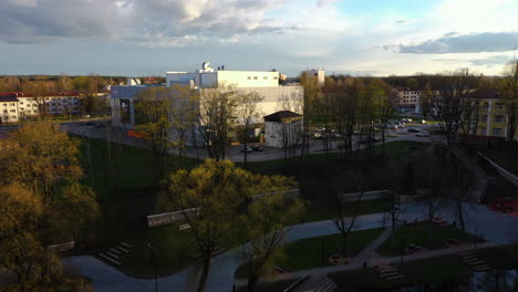 Drohnenaufnahme-Eines-Einkaufszentrums-Und-Überblick-über-Die-Skyline-Von-Valmiera-Bei-Goldenem-Sonnenuntergang