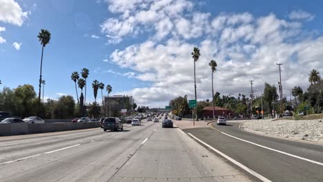 Sunny-day-timelapse-on-110-Fwy-in-Los-Angeles,-cars-speeding-by,-blue-sky-with-fluffy-clouds,-urban-commute