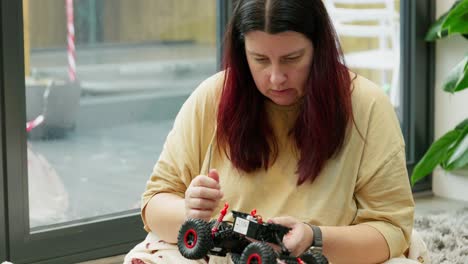 Madre-E-Hijo-En-La-Mañana-De-Navidad-Construyendo-Un-Nuevo-Coche-De-Juguete.