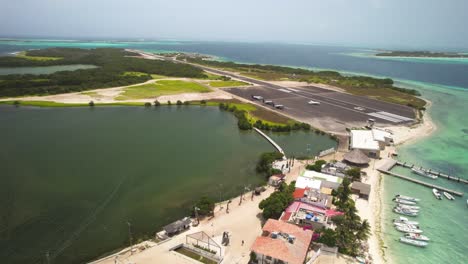 Pista-De-Aterrizaje-De-Los-Roques-En-Venezuela-Con-Aguas-Cristalinas-Y-Barcos,-Día-Brillante,-Vista-Aérea