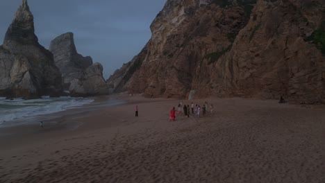 Eine-Gruppe-Glücklicher-Frauen-Tanzt-An-Bewölkten-Tagen-Barfuß-Am-Sandstrand-In-Portugal