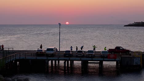 Luftaufnahme-Dolly-Als-Fischer-Bei-Sonnenuntergang-Auf-Docks-Genießen-Goldene-Stunde