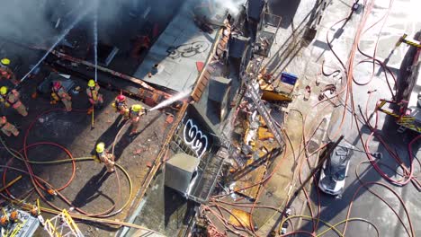 Feuerwehrleute-Löschen-Einen-Dachbrand-Aus-Der-Luftaufnahme-Einer-Drohne-Von-Oben-In-Montreal,-Kanada