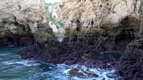 Dunkle-Und-Zerklüftete-Felsformationen-Entlang-Der-Zerklüfteten-Küste-Von-Lagos,-Algarve,-Portugal