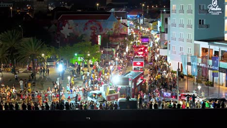 Aerial-pan-ascend-as-trucks-drive-in-streets-of-Caribbean-island-to-celebrate-Carnaval