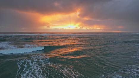 Puesta-De-Sol-Dorada-Con-Cielos-Grises-Y-Nublados-Sobre-El-Mar-De-Tasmania-En-La-Playa-De-Piha-En-Auckland,-Nueva-Zelanda