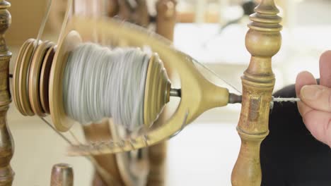 Vintage-Nordic-treadle-spinning-wheel-twists-grey-wool-fibre-into-yarn