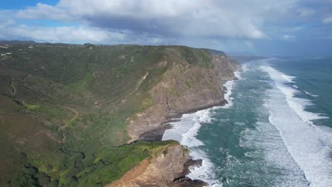 Olas-Del-Mar-Chapoteando-En-Las-Escarpadas-Cordilleras-Waitakere-En-Piha,-Costa-Oeste-De-Auckland,-Nueva-Zelanda