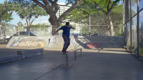 Mann-Fährt-Mit-Dem-Skateboard-Unter-Einer-Brücke-Hindurch-Und-Macht-Dann-Einen-Kickflip-Auf-Das-Geländer