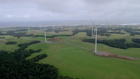 Drone-shot-of-renewable-energy-wind-farm-with-clouds-on-Tasmania's-west-coast,-Australia
