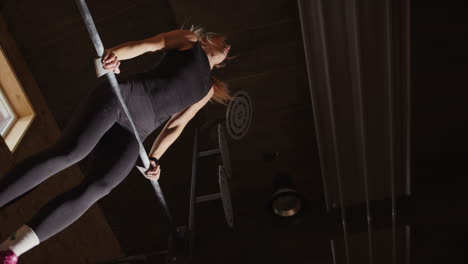 Female-Swedish-athlete-use-bar-to-do-muscle-up-in-gym,-slow-motion-upward-view