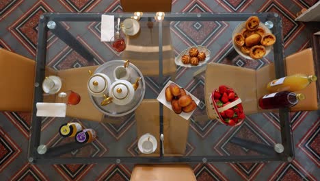 top-down-shot-showing-a-selection-of-pastries-and-fruit-on-a-table-for-breakfast