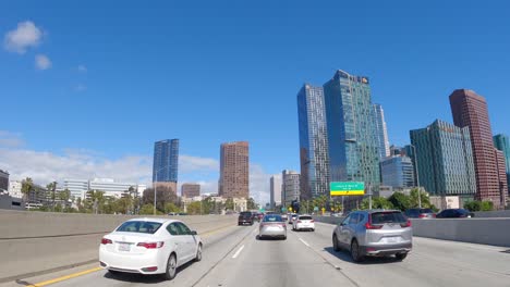 Sonnige-Fahrt-Auf-Dem-Los-Angeles-Highway-Mit-Autos-Und-Skyline,-Tagsüber