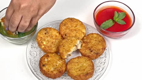 Die-Hand-Eines-Indischen-Kochs-Legt-Schichten-Meethi-Chutney-Saunth-Auf-Aloo-Tikki-–-Straßenessen-Aus-Indien