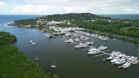 Aerial-Drone-Fly-Marine-Blue-Bay-Yatchs-Port-Douglas-Waterfront,-Green-Forest-Area-north-Queensland-Australia